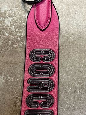 Coach Fuchsia Leather Keychain Strap with Raised Black Detailing.